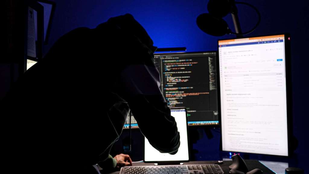 a man sitting in front of a computer monitor